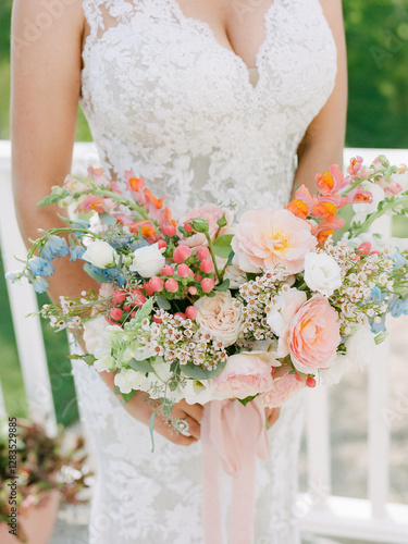 Lush bridal bouquet features pastel flowers for outdoor wedding celebration in springtime garden