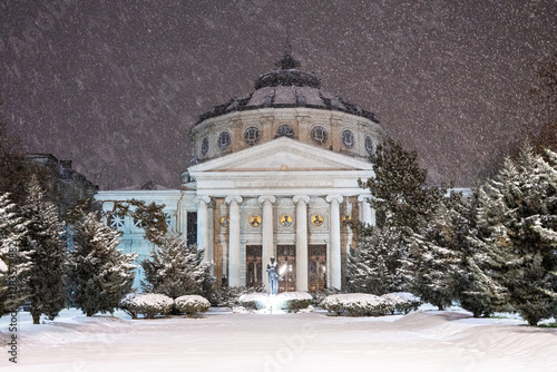 Obraz na płótnie Winter in Bucharest. The Romanian Athenaeum covered in fresh snow at night, with snowfall adding a magical winter atmosphere to the historic landmark in Bucharest. w salonie