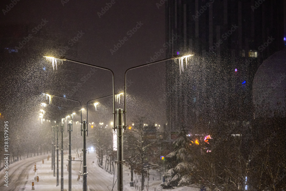 Winter in Bucharest. A row of streetlights covered in icicles during a snowy night in Bucharest, casting a mystical and serene winter glow.