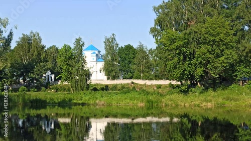 Orthodox Church standing over bank of river. bell ringing during service in church is heard over river. Rural landscape with river church. Service in village church. Religious concept