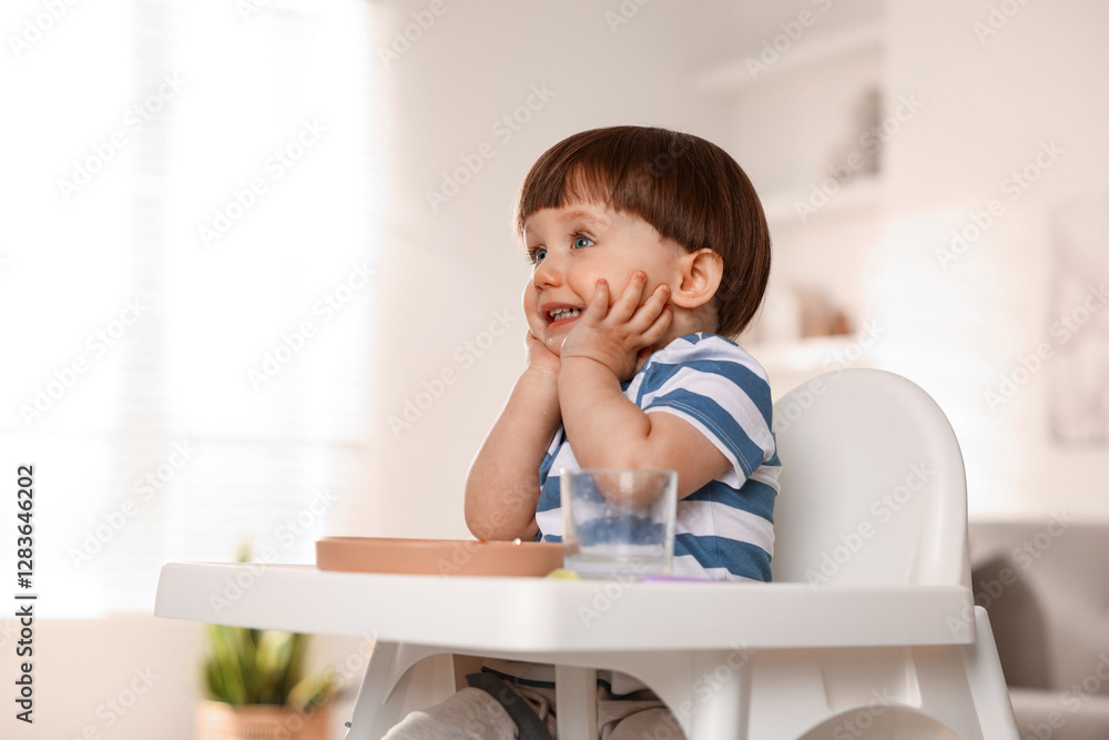 Cute little boy sitting in high chair at home Cute little boy sitting in high chair at home