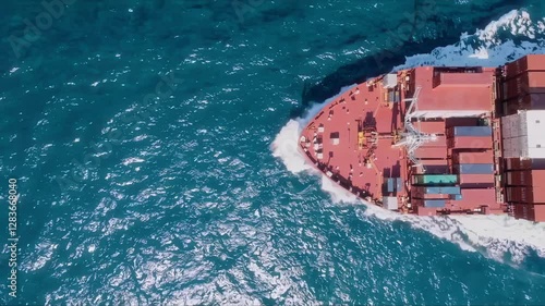 A stunning and vibrant aerial shot of a large cargo ship skillfully navigating through clear, blue ocean waters