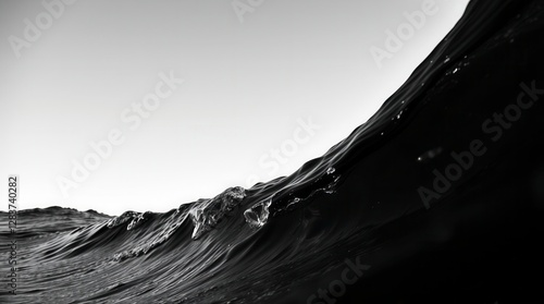 Dramatic monochrome wave crests towards the sky, an abstract dance of water and light.