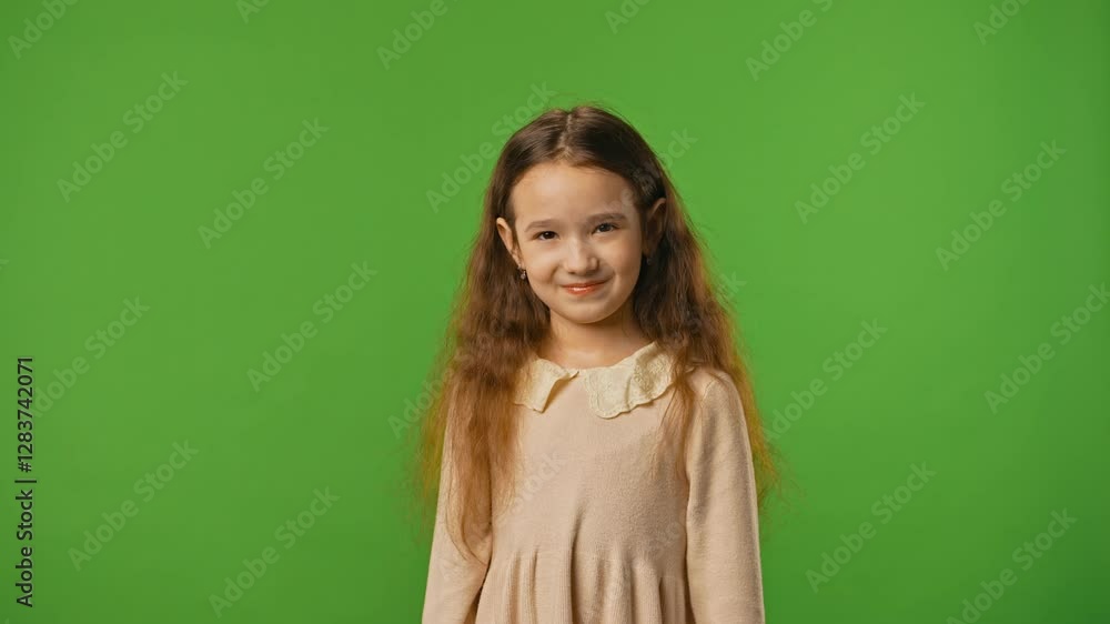Little girl child in shirt standing looking at camera and blinking, smiling expression, isolated on chroma key green screen studio background mockup. Little girl child in shirt standing looking at camera and blinking, smiling expression, isolated on chroma key green screen studio background mockup.