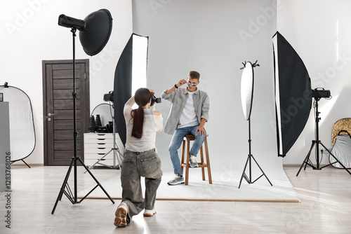 Photographer working with model in professional photo studio