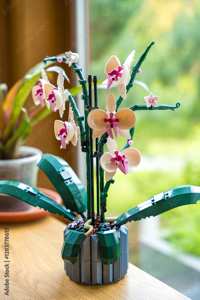 Obraz premium Prague, Czech republic - May 8, 2024: A plastic decorative orchid made from Lego bricks, showcasing an innovative, reusable option that offers durability and environmental appeal over fresh flowers.
