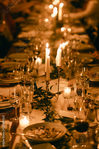 Canvas-taulu Elegant candlelit dinner gathering with beautifully set table adorned with fine