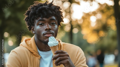 Young african male enjoying ice cream cone in park setting