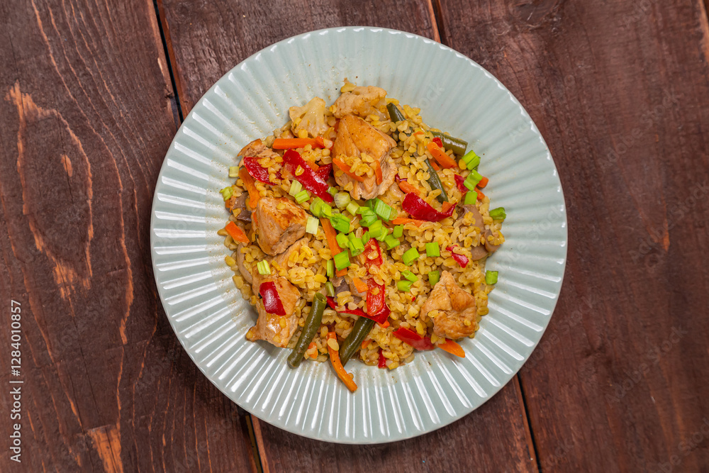 On a wooden table in a plate there are vegetables stewed with bulgur and meat On a wooden table in a plate there are vegetables stewed with bulgur and meat