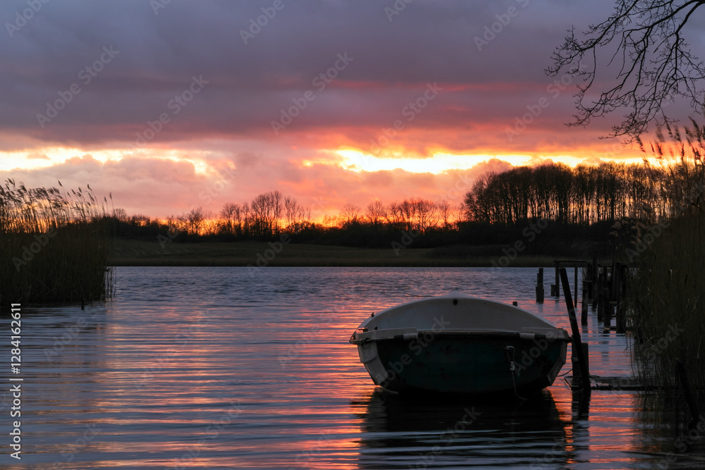 rowboat at the lake with dramatic sunset sky.
