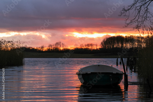 Obraz na płótnie rowboat at the lake with dramatic sunset sky. w salonie