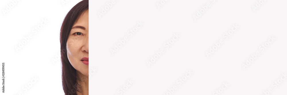 Half-face portrait of mature Korean woman in her 60s with well-kept, glowing, smooth skin looking in camera isolated on white background. Concept of anti-aging skin care. Banner. Copy space for text Half-face portrait of mature Korean woman in her 60s with well-kept, glowing, smooth skin looking in camera isolated on white background. Concept of anti-aging skin care. Banner. Copy space for text