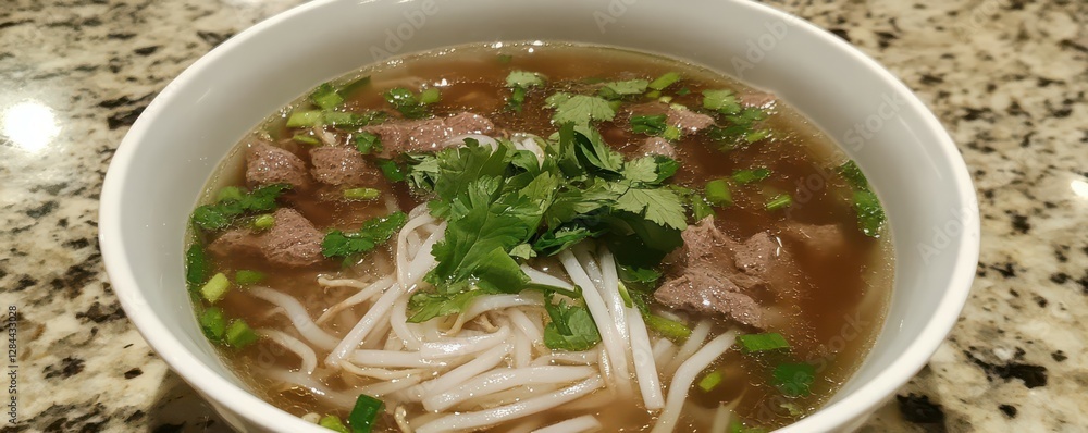 Delicious vietnamese pho with beef, noodles, and fresh herbs in white bowl