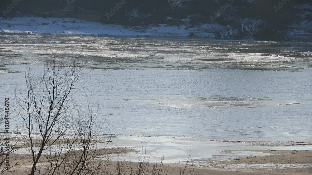 large ice floes float down a wide river on a cold sunny winter day large ice floes float down a wide river on a cold sunny winter day