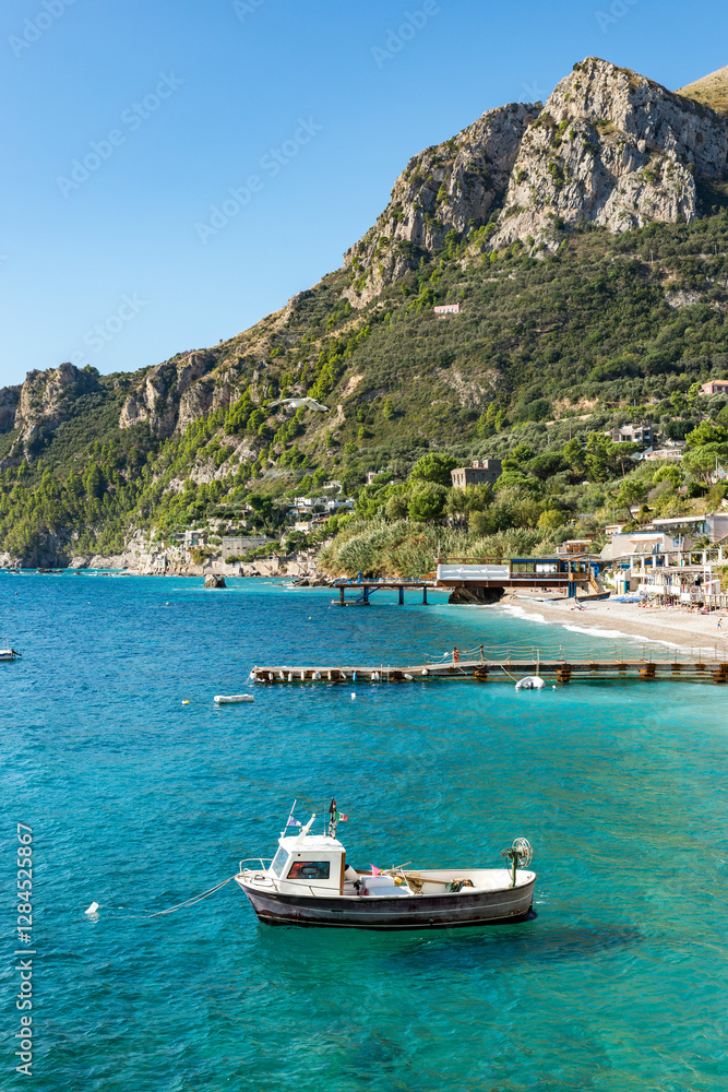 Marina del Cantone: Dream beaches in Massa Lubrense on the Amalfi coast of Italy with crystal clear blue sea, the coast overlooking the sea and moored boats Marina del Cantone: Dream beaches in Massa Lubrense on the Amalfi coast of Italy with crystal clear blue sea, the coast overlooking the sea and moored boats