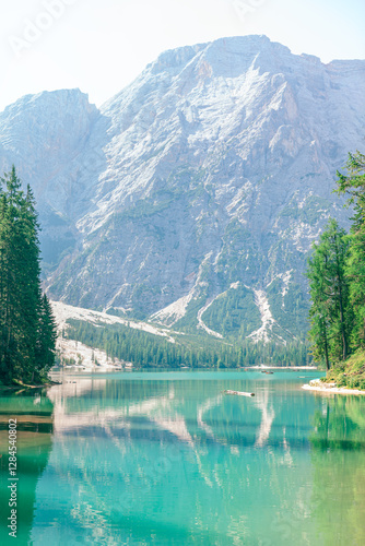 Obraz na płótnie Stunning Alpine lake Pragser Wildsee located in the Dolomites of South Tyrol, Italy. Turquoise water of lake reflects towering, rugged mountains and lush green trees surrounding it w salonie