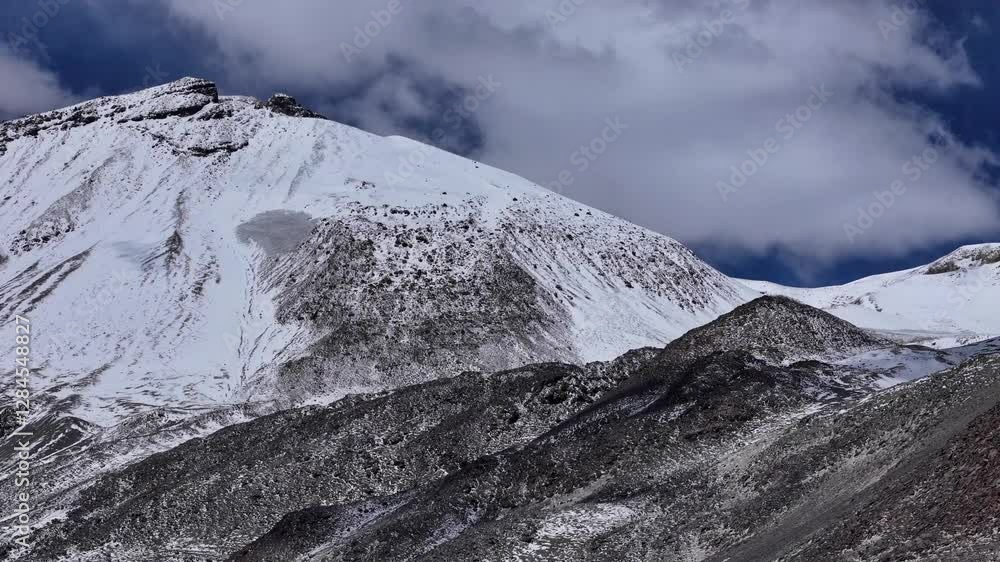 Aerial: Snow-covered mountain peak with dramatic rugged slopes Aerial: Snow-covered mountain peak with dramatic rugged slopes