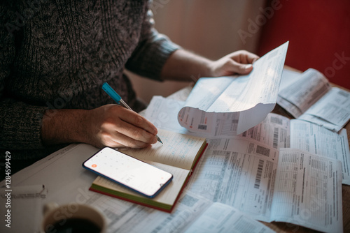 Close-up of men's hands with a calculator and utility bills. The concept of rising prices for heating, gas, and electricity. Lots of utility bills and hands with a calculator and a notebook