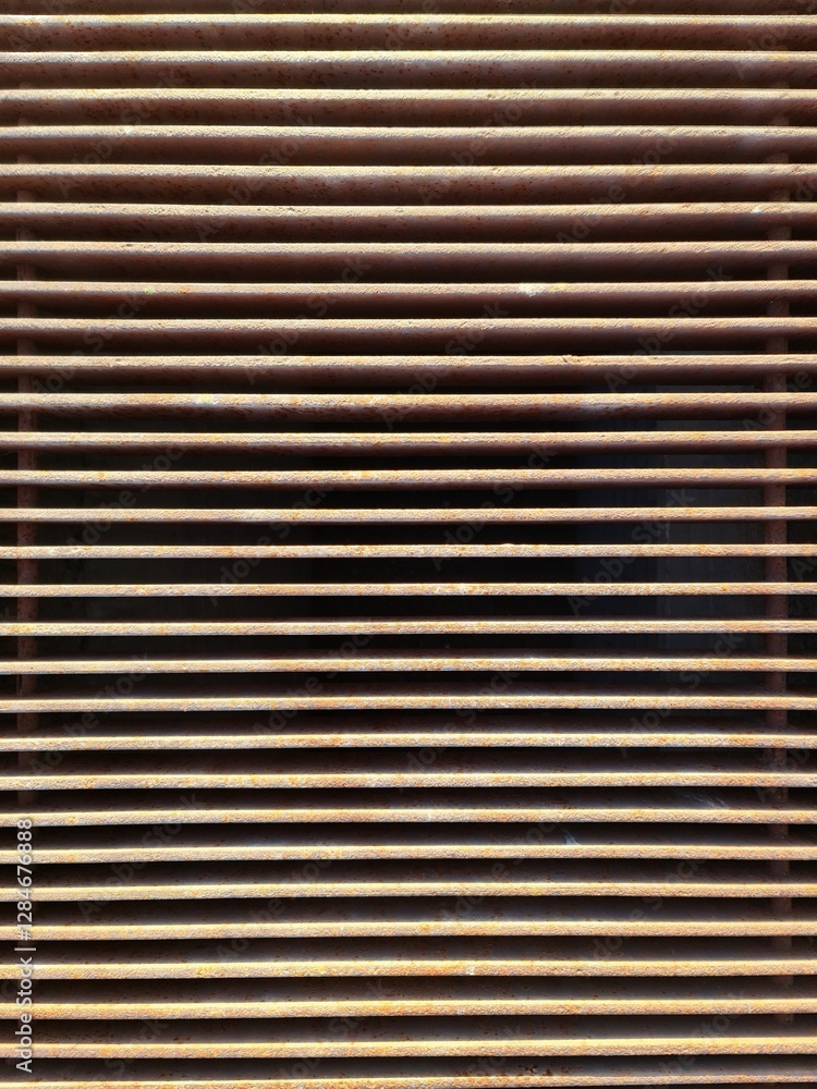 Rusty metal grille creating repeating horizontal lines Rusty metal grille creating repeating horizontal lines