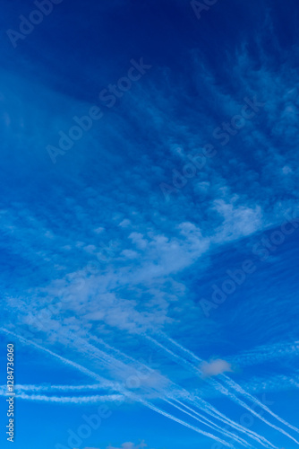 Obraz na płótnie Condensation trails against a blue sky. Photo taken on a sunny day w salonie