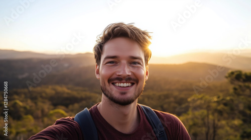 A Caucasian Man in His 30s Smiling While Taking a Selfie in Front of a Scenic Landscape, with a Bright Sky in the Background