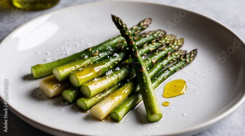 Roasted asparagus with olive oil and sea salt on a white plate
