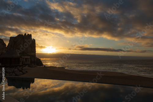 The sun and its rays breaking through at dawn over the Sea of Cortez and reflecting in the pool by the beach.