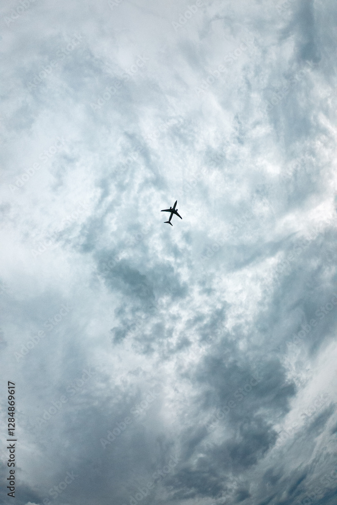 A plane is flying through a cloudy sky