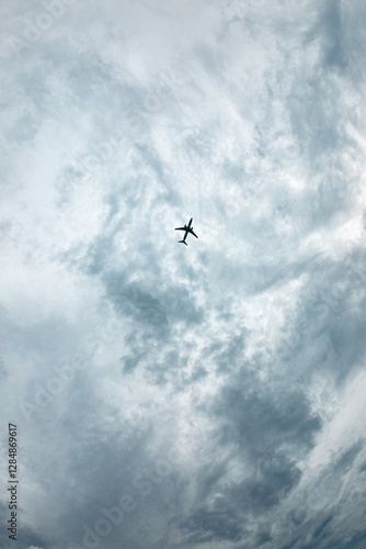 Obraz na płótnie A plane is flying through a cloudy sky w salonie
