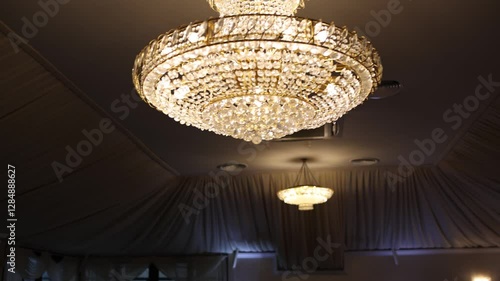a large crystal chandelier hangs from the ceiling in an expensive restaurant