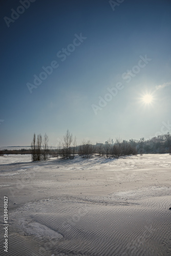 Sand quarry in th Vilnohirsk , Ukraine. Winter landscape on the sand quarry ,sun rays on the sy , beautiful colors on the picture . Path on the sand . Road and trees with lights of the sun . Trees  photo