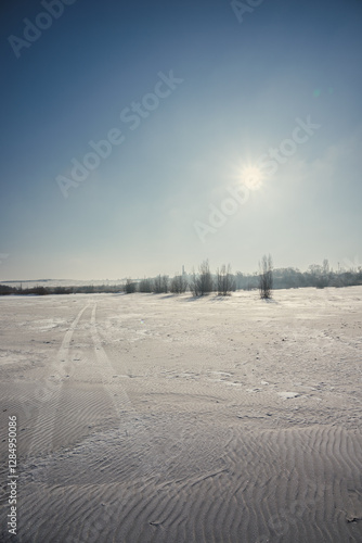 Sand quarry in th Vilnohirsk , Ukraine. Winter landscape on the sand quarry ,sun rays on the sy , beautiful colors on the picture . Path on the sand . Road and trees with lights of the sun . Trees  photo