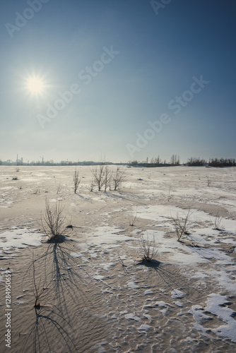 Sand quarry in th Vilnohirsk , Ukraine. Winter landscape on the sand quarry ,sun rays on the sy , beautiful colors on the picture . Path on the sand . Road and trees with lights of the sun . Trees  photo