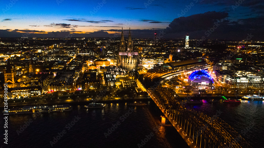 Obraz premium Night drone view of centrum of Cologne in Germany by sunset. Seen showing famous Dom-Cathedral, bridge , rive Rhein and Opera all in downtown