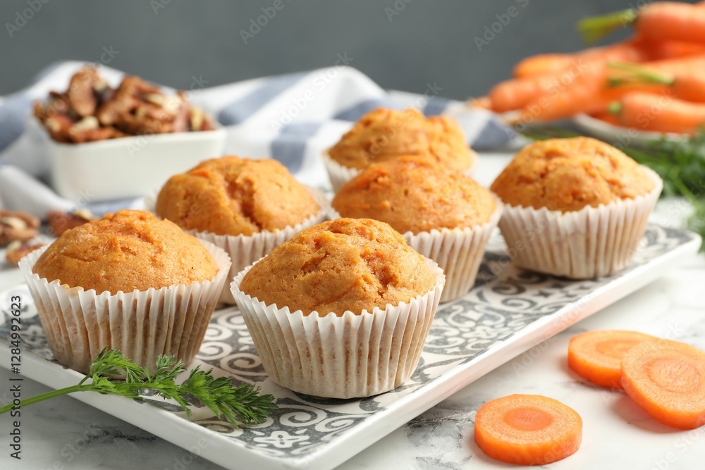 Tasty carrot muffins, fresh vegetables and walnuts on white marble table, closeup Tasty carrot muffins, fresh vegetables and walnuts on white marble table, closeup