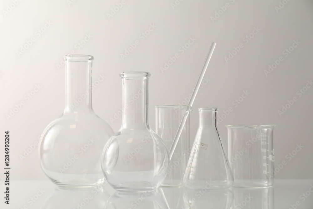 Many different laboratory glassware on light background Many different laboratory glassware on light background