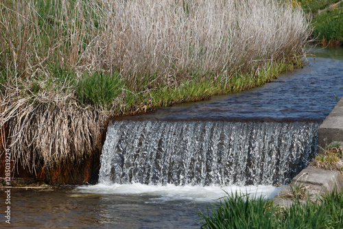 Water flowing over a weir dam in a small river