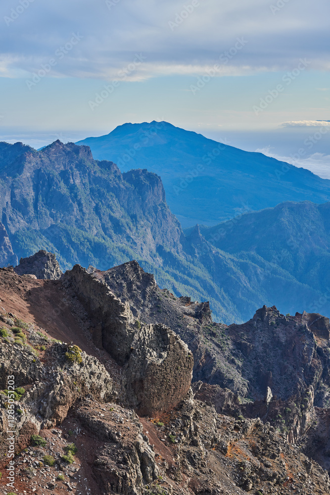 Obraz premium Mountains, rocks and terrain on landscape, outdoor and sky on island with geology, trail and summer in environment. Cliff, stone and sunshine with hill, valley and path for tourism in La Palma, Spain