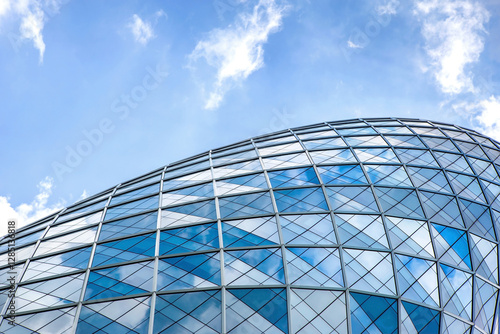 Blue sky and clouds reflecting in windows of modern office building