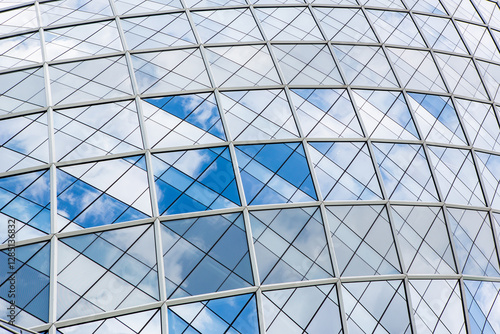 Blue sky and clouds reflecting in windows of modern office building