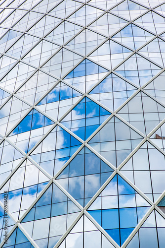 Blue sky and clouds reflecting in windows of modern office building