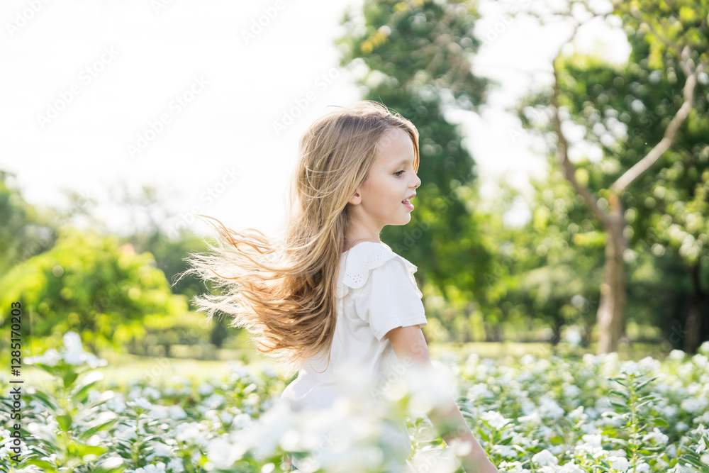 Little girl playing in the garden with morning sunrise Little girl playing in the garden with morning sunrise