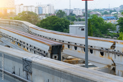 Switching change transition move direction track Inscription - Danger high voltage. Modern mass transit. Rail transportation. Driverless straddle monorail on concrete guideway beam conductor rail. photo