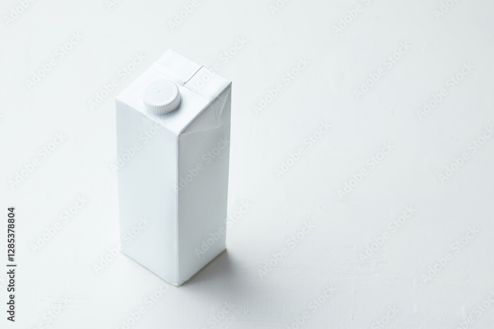 Fototapeta premium Simple White Carton on a Clean Surface With a Modern Design in Natural Light