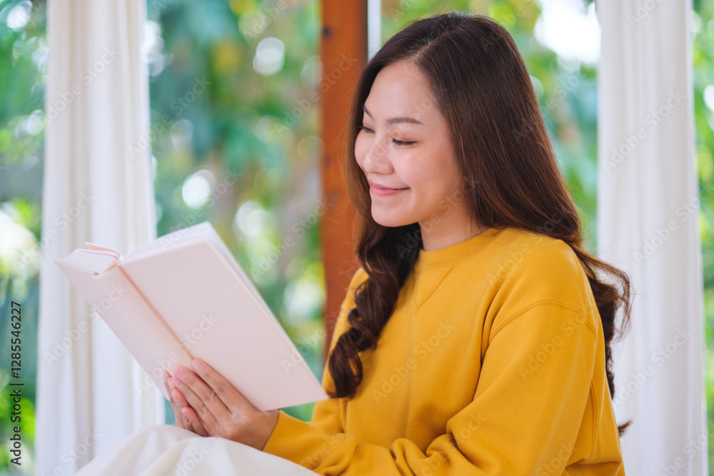 Portrait image of a young woman reading a book at home Portrait image of a young woman reading a book at home