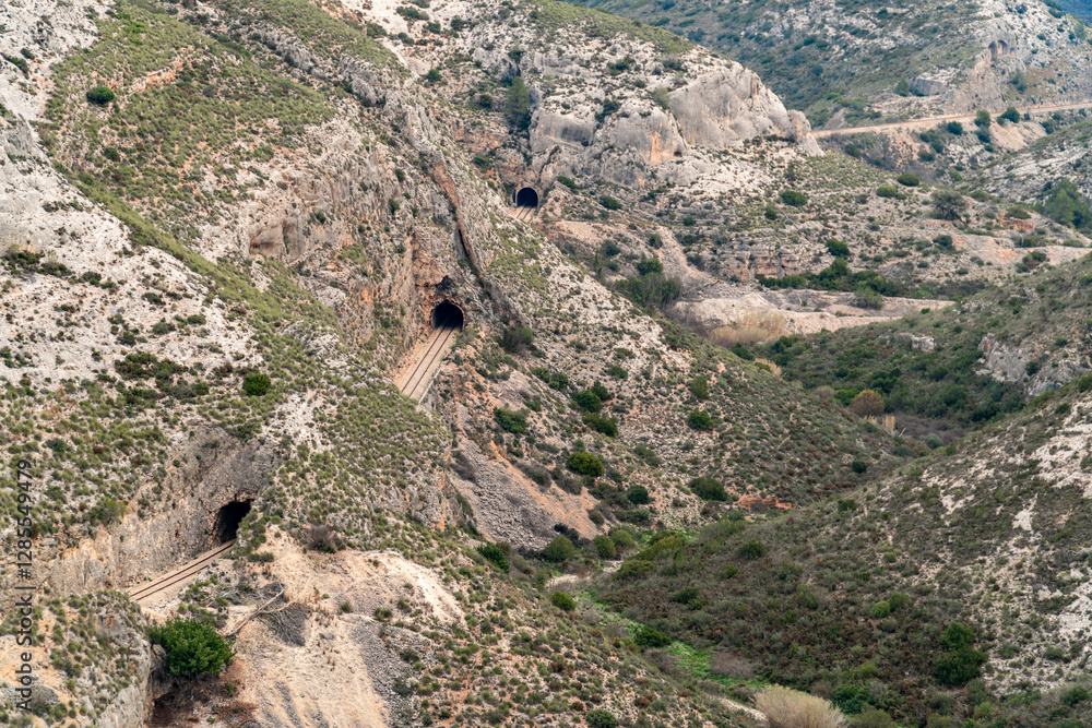 Fototapeta premium Mountainous landscape with a railway track and tunnels