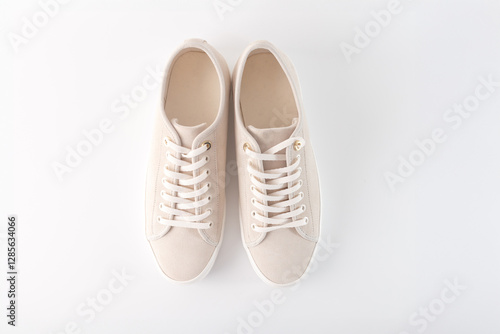 Beige sneakers with white laces and gold eyelets, placed side by side on a white background. Perfect for fashion brands, shoe retailers, or e-commerce businesses showcasing minimalist footwear, photo