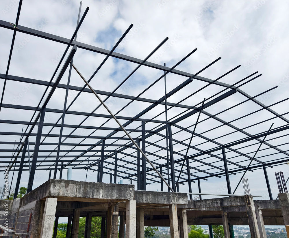 Building roof under construction with a cloudy sky behind Building roof under construction with a cloudy sky behind