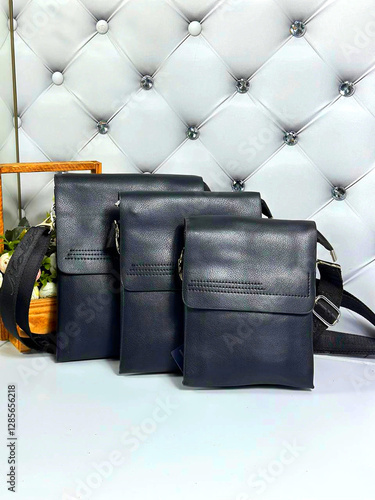 Three black leather handbags with a black strap