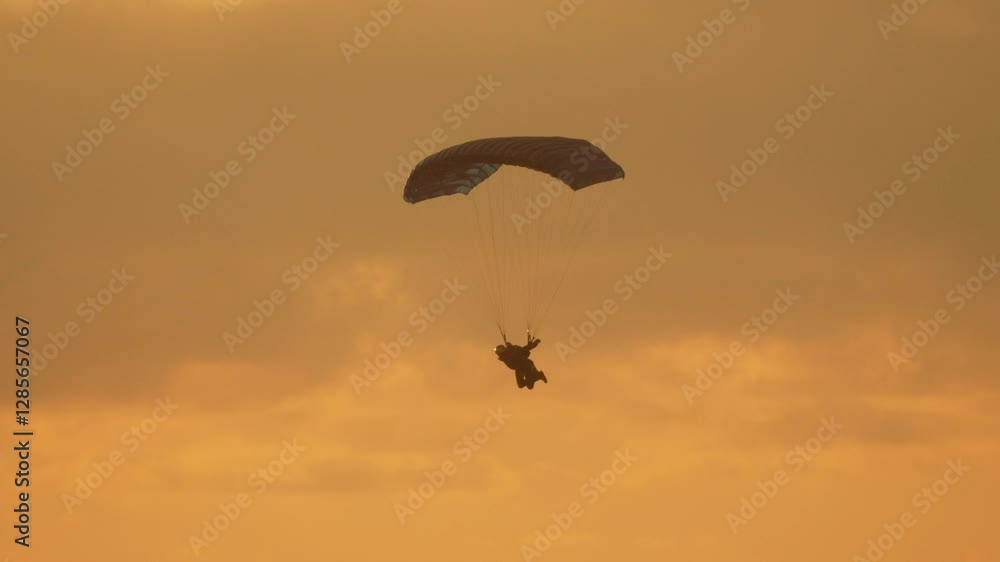 Skydiver Descending Against a Golden Sunset Skydiver Descending Against a Golden Sunset